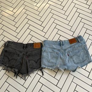 Levi’s vintage denim shorts in washed blue and washed black with rips.
